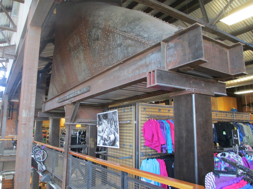 Eine Szene mit verschiedenen Gegenständen wie Kleidung, Lampen, Metallstangen, Karren und einem Zaun.