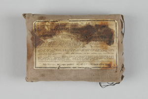 Eine kleine Tasche mit einem Stück Papier darauf, wahrscheinlich ein Verbandskasten, mit Text auf dem Papier.