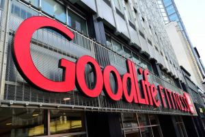 Außenansicht eines Goodlife Fitness Studios in New York City mit Glaswänden, einem Namensschild, benachbarten Gebäuden und Himmel im Hintergrund.