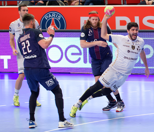 Männer beim Handballspielen auf einem Court mit einem Ball im Spiel, Zuschauer im Hintergrund und ein Banner mit der Aufschrift "Futsal-Weltmeisterschaft 2019 - Paris Saint-Germain vs. Marseille."