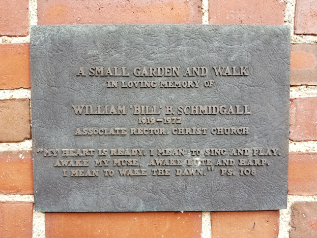 Eine Backsteinmauer mit einer Gedenktafel, die "Ein kleiner Garten und Spaziergang in liebevoller Erinnerung an William B. Schmidgall" trägt.