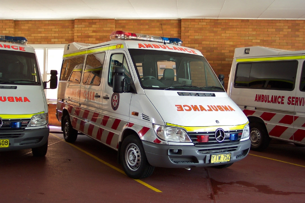 Ein Rettungswagen in Weiß steht vor einer Backsteinwand.