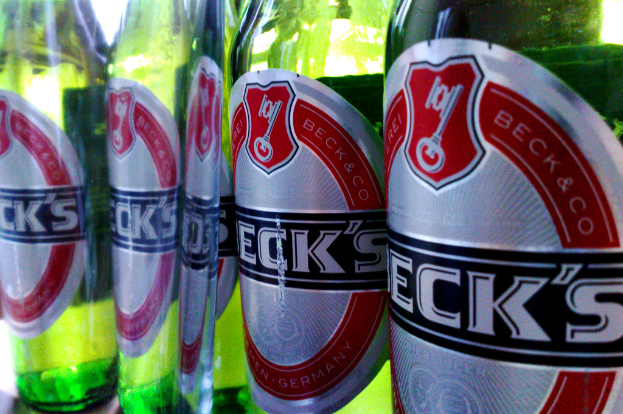 Eine grüne Bierflasche mit einem Etikett daran.