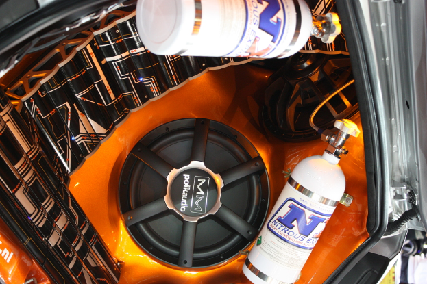 Ein Autosoundsystem mit Lautsprechern, Zylindern und einem schwarz-weißen Objekt.