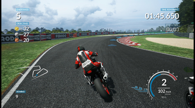 Eine Person in einem roten, weißen und schwarzen Kleid fährt auf einem Motorrad auf einer Straße mit Gras, Geländern, Brettern und Bäumen unter einem Himmel.