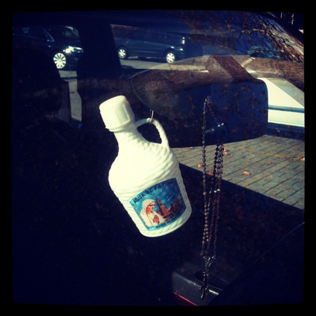 Ein Auto steht mit einer Kette und einer Flasche in der Nähe auf der Straße.