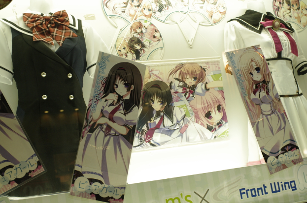 Schaufensterpuppen in verschiedenen Kostümen mit Cartoon-Bildern an der Wand dahinter.