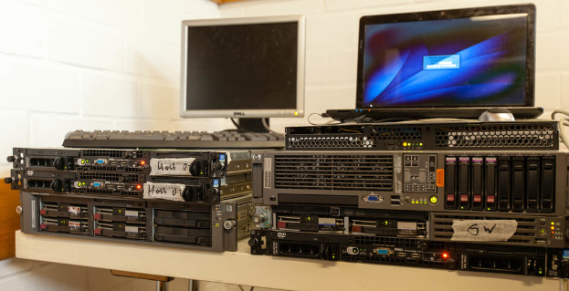 Ein Tisch mit Monitoren und elektrischen Geräten darauf.