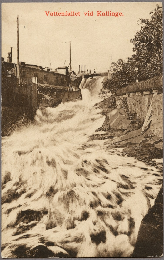 Altes Schwarz-Weiß-Foto eines Flusses mit fließendem Wasser, umgeben von Bäumen, Gebäuden, Strommasten und einem Zaun, mit Text oben.