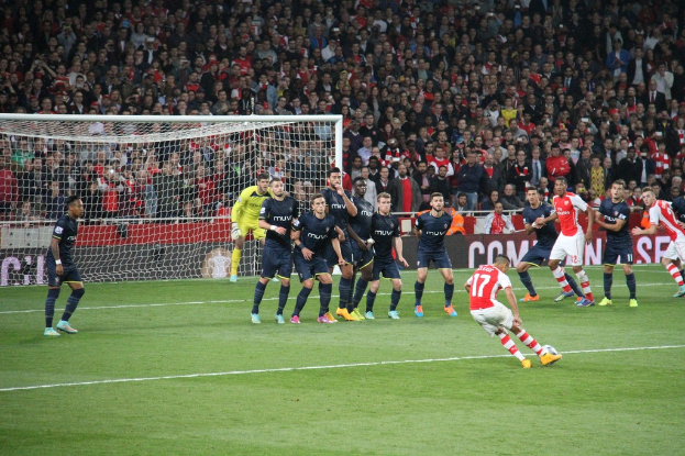 Fußballspieler auf dem Feld mit einer grossen Menge im Hintergrund.