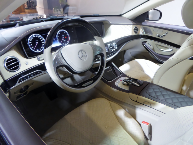 Das Innere eines Mercedes S-Klasse Limousinen zeigt ein luxuriöses Lenkrad, bequeme Sitze, ein elegantes Armaturenbrett mit verschiedenen Knöpfen und Drehreglern sowie ein großes Touchscreen-Display.