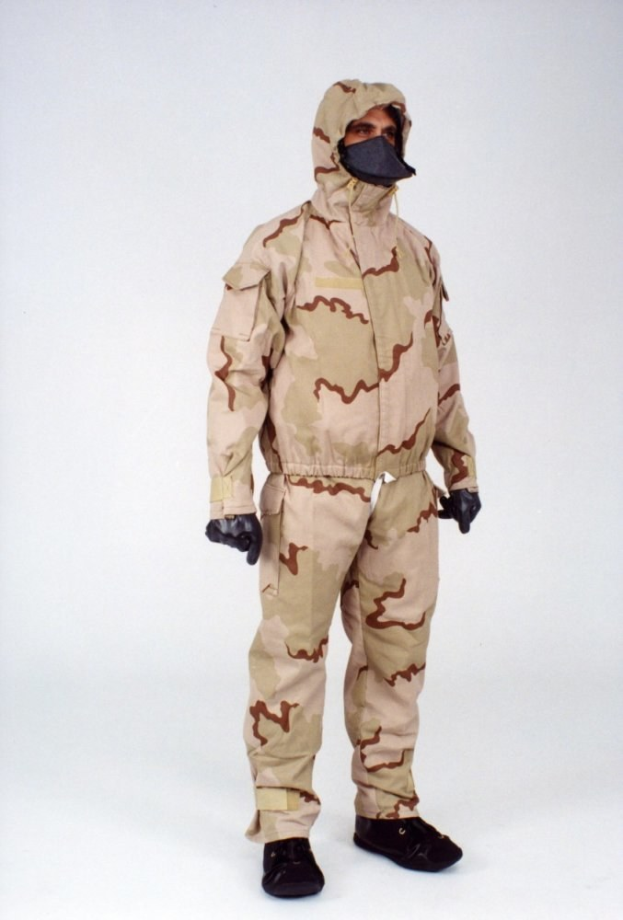 Mann in einem Tarnmuster-Schutzoverall und Kapuzenmaske vor einem weißen Hintergrund.