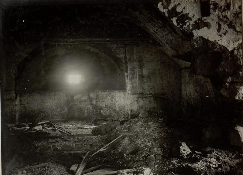 Ein Schwarz-Weiß-Foto eines einstürzenden Tunnels in den Ruinen der Berliner Mauer, mit Schutt auf dem Boden und einem Licht am Ende.