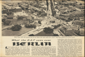 Schwarz-weiß-Fotografie einer alten Zeitungsseite mit einer Stadtansicht, die Gebäude, Bäume und Fahrzeuge zeigt, begleitet von Text.