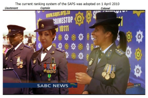 Gruppe von Menschen in Uniformen und Hüten mit einer Fahne, auf der oben und unten Text steht "Das aktuelle Ranking-System der SAP wurde am 1. April 2010 eingeführt."