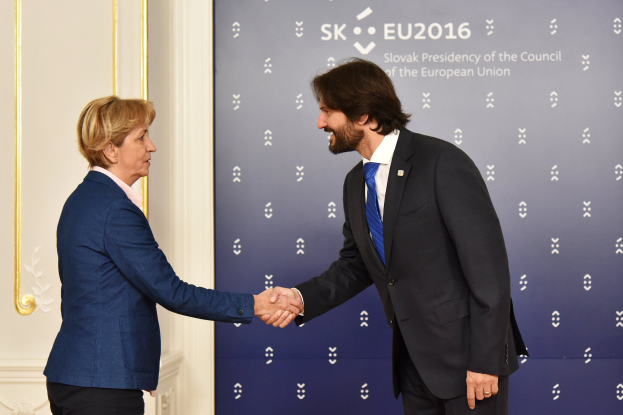 Bundeskanzlerin Angela Merkel und Bundespräsident Joachim Gauck schütteln sich vor einem Banner mit der Aufschrift "EU-Gipfel" die Hände und lächeln freundlich.