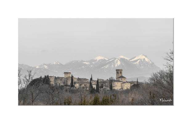 Ein Schloss in der Mitte des Bildes, mit Bäumen unten, Hügeln und Himmel im Hintergrund.