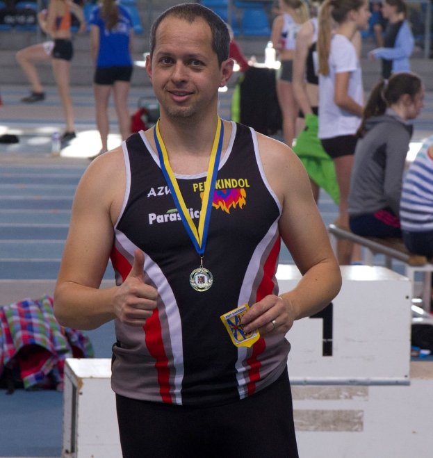 Ein Mann in schwarzer Jerseystand vor einer Gruppe von Menschen, die trainieren.