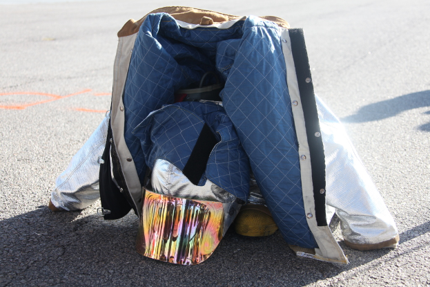Eine Jacke und verschiedene Gegenstände liegen auf der Straße verstreut.