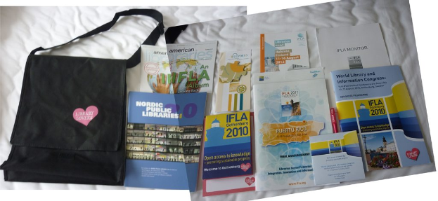 Eine Tasche mit 'Bibliotheksliebhaber' darauf und einige Bücher auf einem Bett.