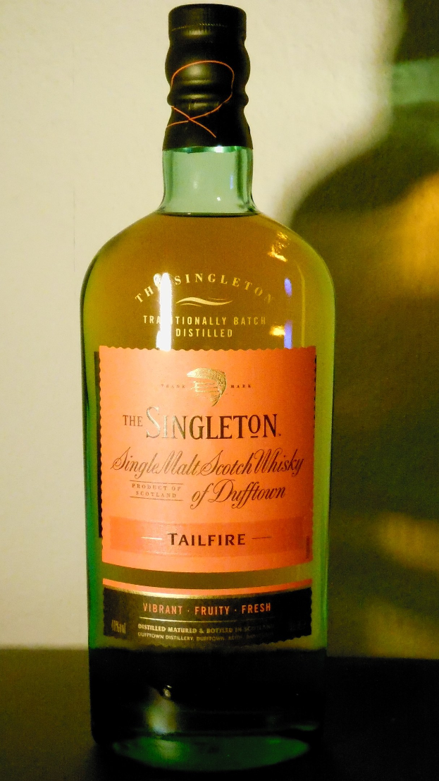 Flasche von Singleton of Dufftown Tailfire Single Malt Scotch Whisky in tiefem Bernstein mit schwarzer Etikettierung, die ein Löwen- und Schlosswappen zeigt.