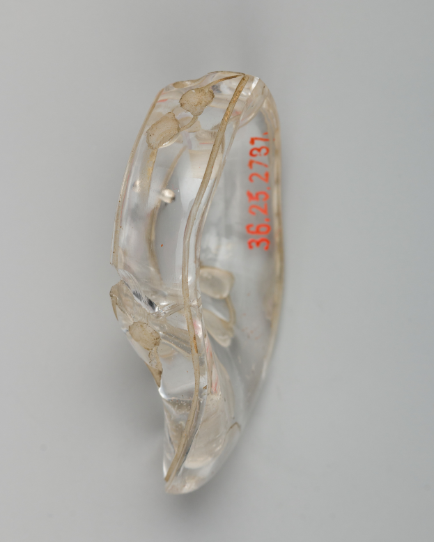 Ein Nahaufnahme eines klaren Hörgeräts auf einer weißen Oberfläche, mit darauf geschriebenem Text.