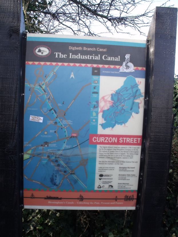 Eine Karte auf Stangen mit einem Wald im Hintergrund.